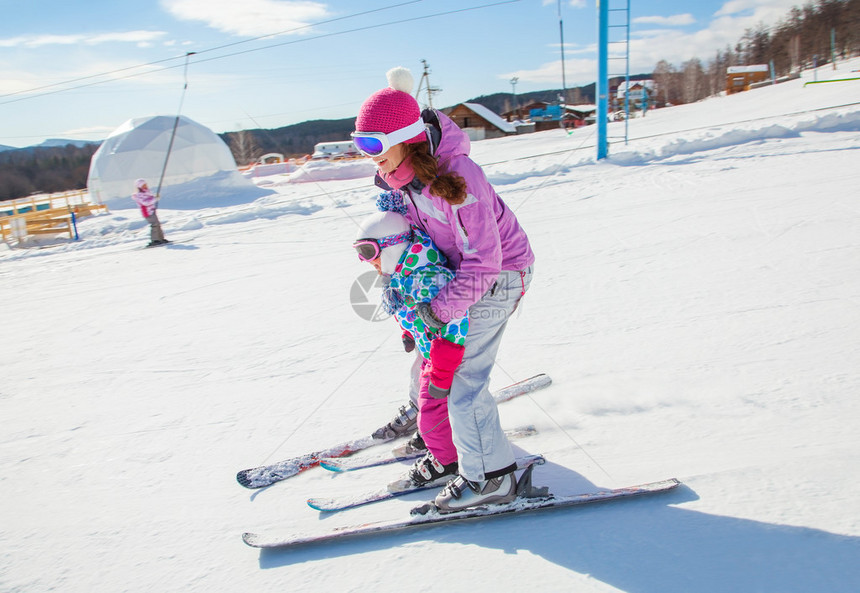 女教练在冬季度假胜地教孩子滑雪图片