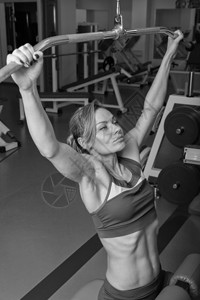 美丽的女孩在健身房锻炼锻炼身体的肌肉女子健身体育杂志海报图片