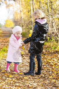 秋季大自然中穿着橡胶靴的小女孩图片