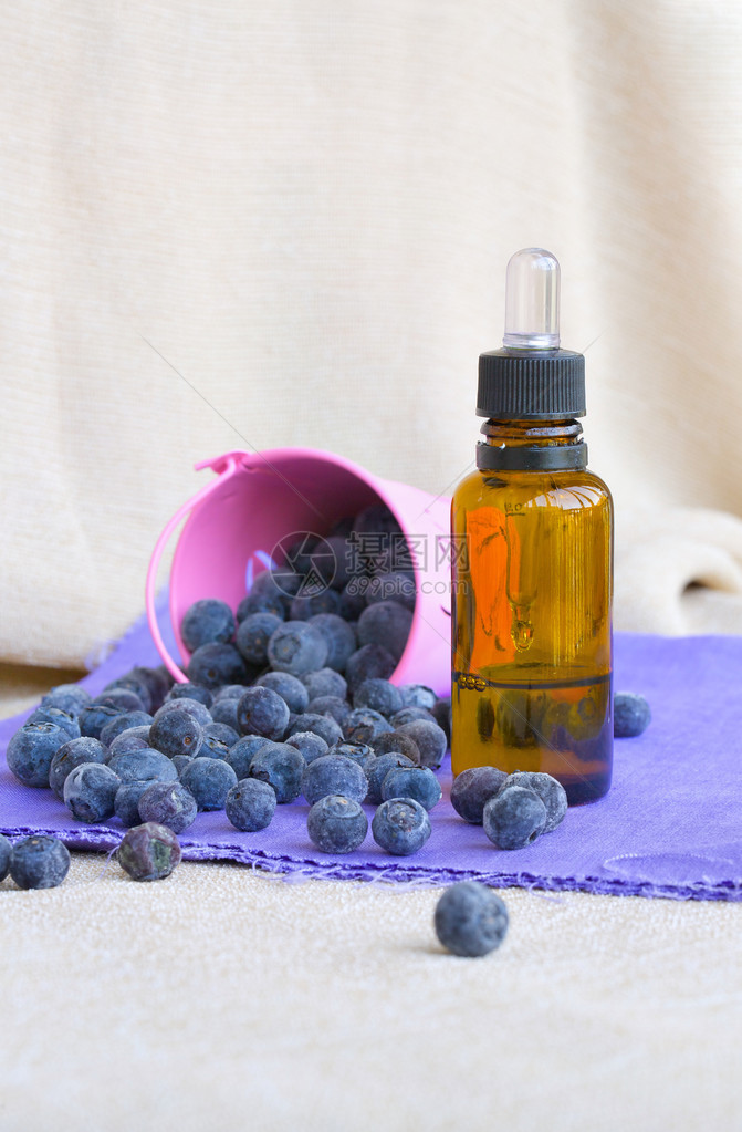 香水瓶蓝莓种子油和紫花布图片