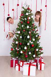幸福的父母和女儿圣诞树上装饰美图片
