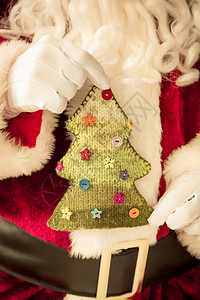 圣诞老人手里拿着针织的圣诞树图片