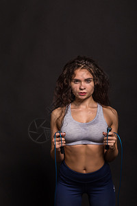 美丽的运动女孩在深色背景上展示身体的肌肉美丽的atletky专业机构体育杂志海报背景图片