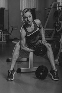 美丽的女孩在健身房锻炼锻炼身体的肌肉女子健身体育杂志海报图片