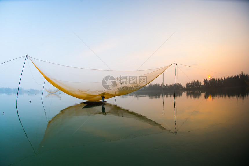 不明身份的渔民清晨在越南霍安河上检查自己的渔网图片