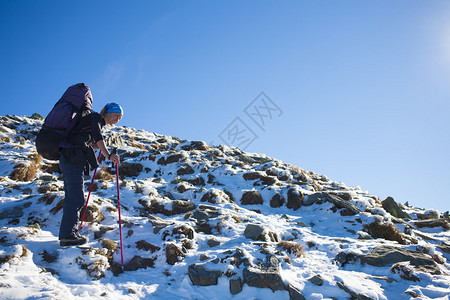 登山者爬上危险的雪坡图片