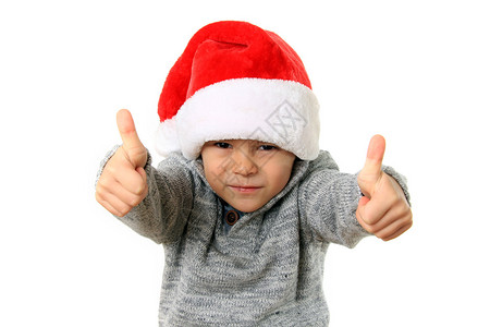 五岁男孩戴着圣诞老人的帽子双手举高图片