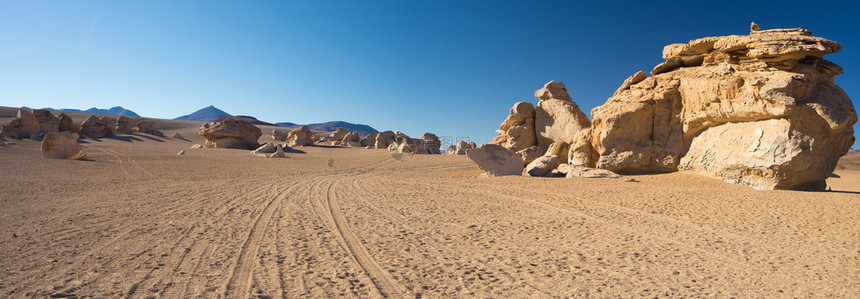 高海拔的土路与沙质漠和安第斯高地风景秀丽的岩层图片