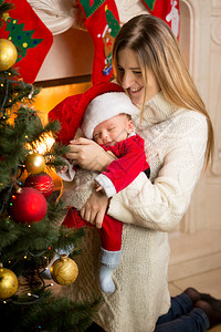 圣诞树装饰的幸福母亲和图片