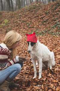 年轻女子与她的狗一起在森图片