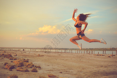 美丽的年轻女子在户外高跳跃时玩得开心的画面图片