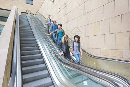 一群年轻的多民族朋友在自动扶梯上下楼图片