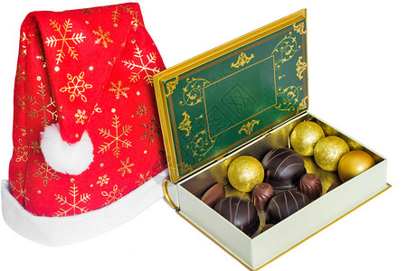 一盒圣诞巧克力和一顶圣诞老人帽子白色背图片