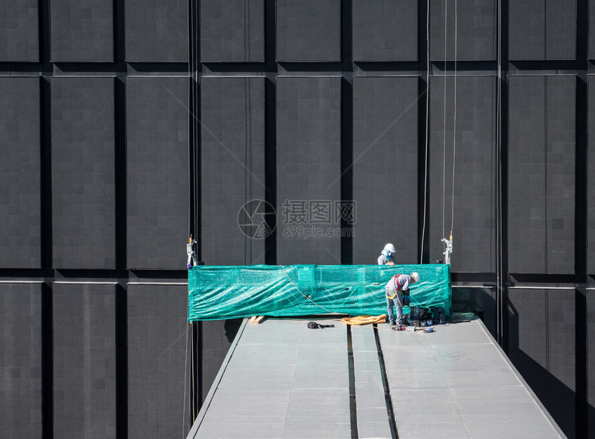 工人在乘电梯爬到高处之前准备工具高层建筑外的维护是一图片