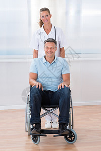 快乐的女医生带着轮椅上的男病人图片