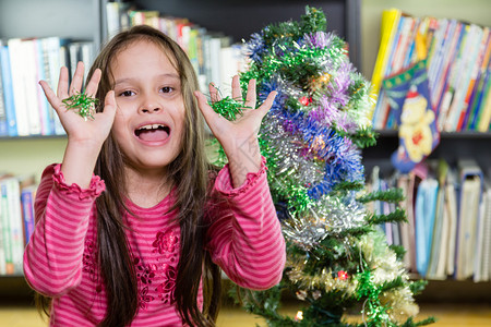 小女孩愉快地装饰圣诞树图片