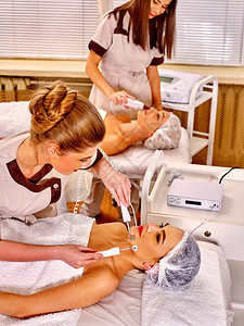 在美容院接受电动加热式脸部按摩手术的妇图片