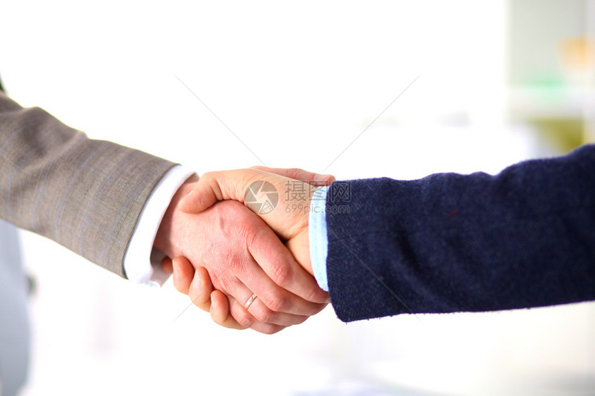 两个商人在办公室里和他们握手互相握手的图片