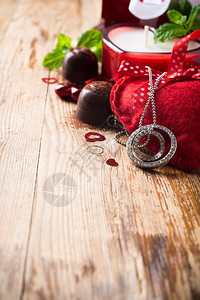 情人节配有巧克力糖果套装戒指蜡烛和古老木质背景的心图片