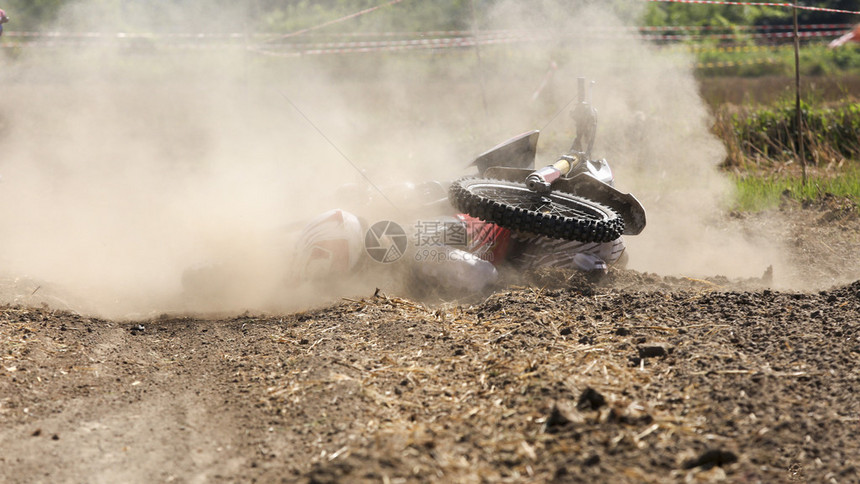 骑手越野摩托车在赛道上摔倒图片