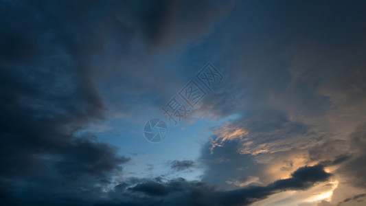 黄昏的夕阳天空阴云密布阳光透过云层图片