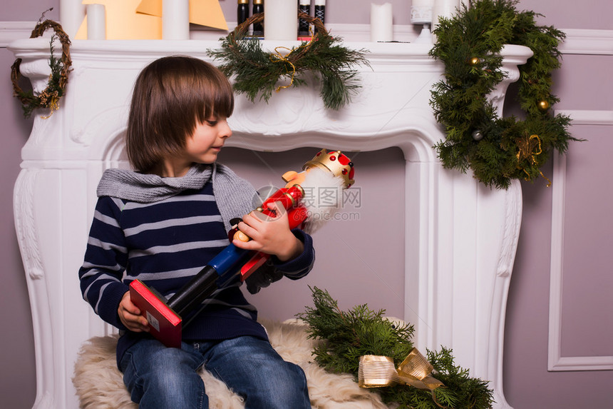 圣诞节日圣诞背景带玩具的漂亮男孩的概念图片