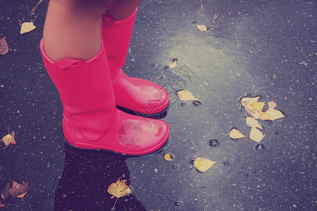 有粉红色雨靴的女人在雨季秋天图片