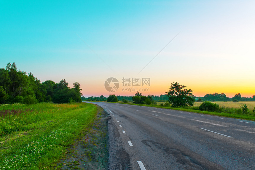 道路和日落天空与绿色森林抽象背景图片