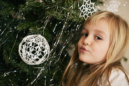 有圣诞树的小女孩特写图片