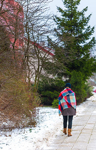 女孩在冬天走人行道身着温暖衣服和图片