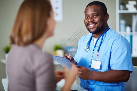微笑的医生在办公室与病人交流图片