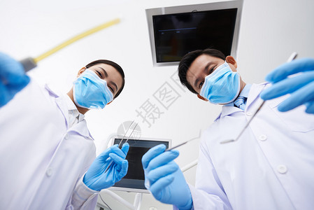 牙科医生及其护士准备检查病人图片