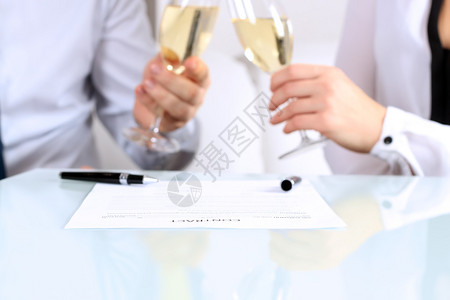 两位同事庆祝与香槟签署合同并庆祝他们签图片