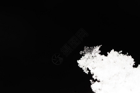 黑色背景隐藏的单颗雪晶图片