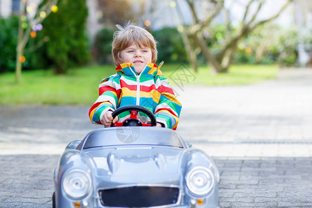幼儿小男孩驾驶大型玩具老旧车图片