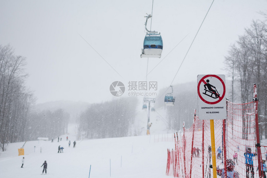 下雪了背景是被雪覆盖的森林和人们滑雪重点是标图片