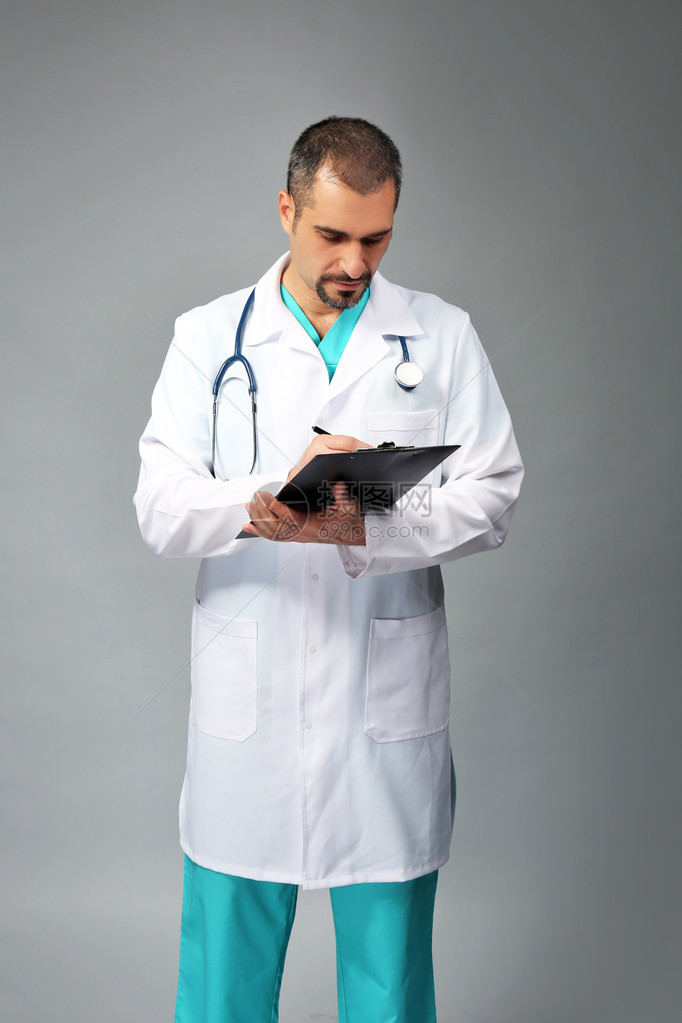 一名医生的处方板被灰色背景人手握图片