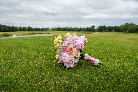新娘花束躺在巨大的绿色草坪上打高尔夫球图片