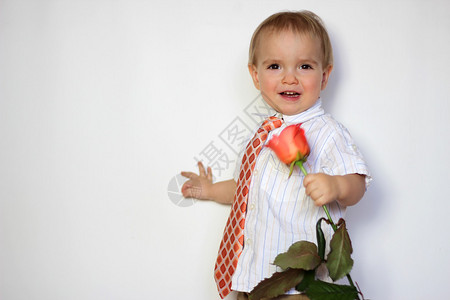 小男孩手握着鲜花图片