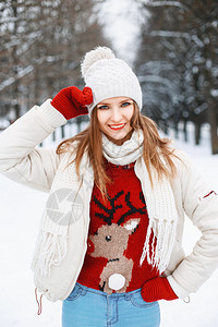 年轻漂亮的时装女孩穿着红色毛衣的红毛衣有一只鹿在图片