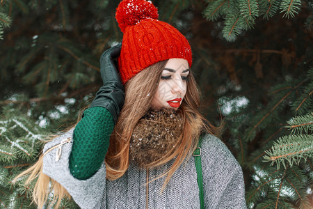 穿着红帽子和绿色毛衣的年轻时装女孩站在图片