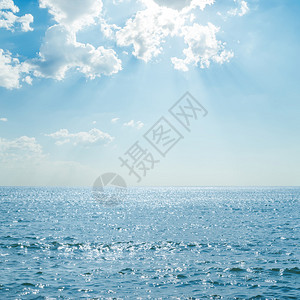 蓝色的大海云彩和阳光下的倒影图片