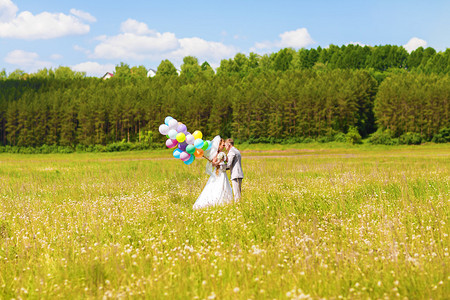 美丽的新娘在公园里拿着一堆气球新娘和新郎夫妇用气球有户外气图片