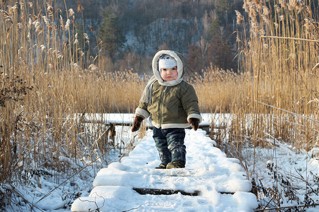 在寒冷湖岸边玩乐的小孩冬天冬图片
