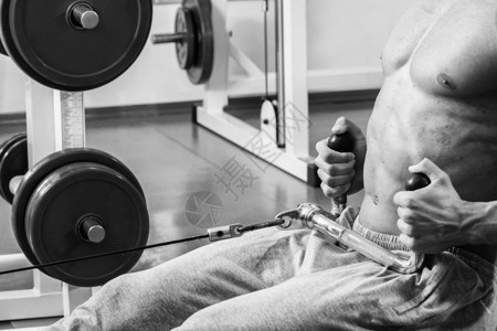 强壮的肌肉男在健身房里锻炼图片