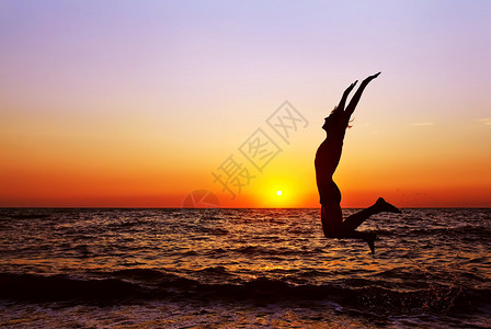 快乐男人在海上日落上跳跃的假影健康的生活方式自由灵感和突图片