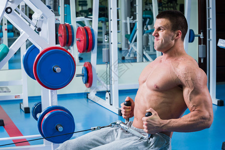 强壮的肌肉男在健身房锻炼图片
