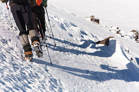 一群徒步旅行者在山上爬到顶部登图片