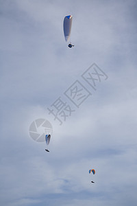 3个滑翔伞在云彩白蓝图片