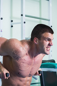 强壮的肌肉男在健身房锻炼漂亮的身体健图片